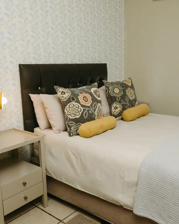 The double bedroom of a BIWEDA family unit, with a padded headboard and garden window